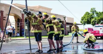  ?? FILE PHOTO ?? MEMBERS OF THE ARIZONA WESTERN COLLEGE FIRE ACADEMY TEAM spray water in a recent Fire Muster competitio­n in Yuma’s downtown. The competitio­n takes place again Saturday on Main Street.