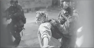  ?? NATHAN HOWARD/GETTY ?? Federal officers arrest a protester after she crossed a fence line set up around the Mark O. Hatfield U.S. Courthouse on Thursday in Portland, Oregon. State and city elected officials have called for the federal officers to leave Portland as clashes continue to escalate.