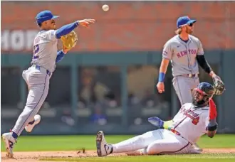  ?? AP PHOTO/MIKE STEWART ?? New York Mets shortstop Francisco Lindor, left, throws toward first base after making the play at second to put out Atlanta Braves designated hitter Marcell Ozuna in the second inning Thursday at Truist Park.