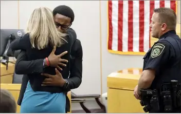  ?? ASSOCIATED PRESS ?? Botham Jean’s younger brother Brandt Jean hugs convicted murderer and former Dallas Police Officer Amber Guyger after delivering his impact statement to her after she was sentenced to 10 years in jail on Oct. 2 in Dallas. Guyger shot and killed Botham Jean, an unarmed 26-year-old neighbor in his own apartment last year. She told police she thought his apartment was her own and that he was an intruder.