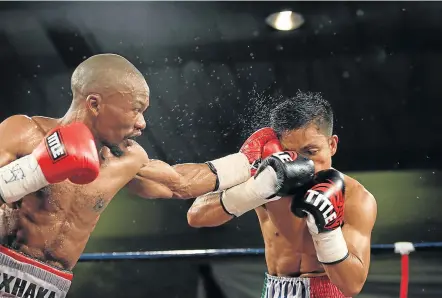  ?? Picture: MICHAEL PINYANA ?? GETTING THROUGH TO HIM: Simpiwe Konkco lands a left to the side of Toto Landero’s head during their IBO mini-flyweight title bout in Mthatha last weekend.