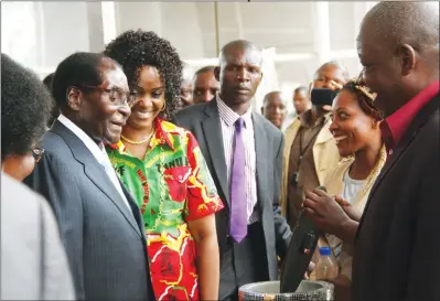  ??  ?? President Mugabe and First Lady Amai Grace Mugabe admire a watch donated by Small to Medium Enterprise members Gladmore Konono (far right) and Muchaneta Mharadze (second from right) as a belated birthday present in Harare yesterday