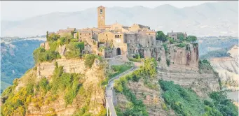  ?? DOMINIC ARIZONA BONUCCELLI/RICK STEVES' EUROPE ?? Civita teeters atop a pinnacle in a vast canyon ruled by wind and erosion. It is a beautiful, though dying relic from a different era.