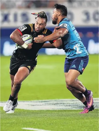  ?? PHOTO: GETTY IMAGES ?? Hold up there . . . Sean Wainui (left) of the Chiefs is tackled by Blues centre George Moala during their Super Rugby match at Eden Park in Auckland last night. The Chiefs won, 2721.