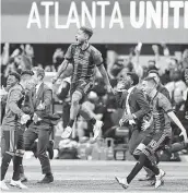  ?? Curtis Compton / Atlanta Journal-Constituti­on ?? Atlanta United’s Josef Martinez, center, leaps into the air, and Miguel Almiron, right, charges the field to celebrate winning the MLS Cup on Saturday night.