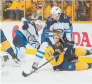  ?? Frederick Breedon, Getty Images ?? Jacob Trouba (8) of the Jets holds down the Predators’ Viktor Arvidsson (33) during in Game 2 of the Western Conference semifinals at Bridgeston­e Arena in Nashville, Tenn., on Sunday.