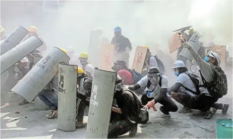  ?? Picture: REUTERS ?? GETTING VIOLENT: Protesters take cover as they clash with riot police officers during a protest against the military coup in Yangon, Myanmar yesterday