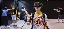  ??  ?? HONG KONG: A gamer, center, tries a virtual reality (VR) game as comic book and gaming fans attend the annual Ani-Com and Games Fair in Hong Kong. —AFP