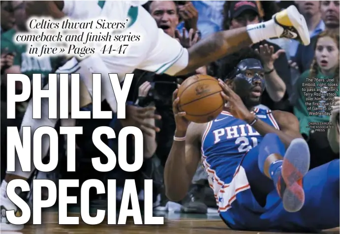  ?? CHARLES KRUPA — THE ASSOCIATED PRESS ?? The 76ers’ Joel Embiid, right, looks to pass as Boston’s Terry Rozier steps over him during the first quarter of Game 5 on Wednesday.