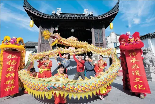  ??  ?? Fiona Li and Shirlene Gu join the local dragon dance team to experience Sanlin’s most famous intangible culture heritage.