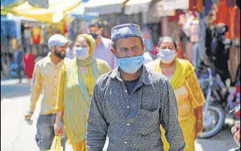  ?? AP ?? People wearing masks as a precaution against coronaviru­s at a market in Jammu.