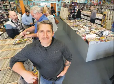  ?? PHOTOS BY TONY DEJAK — ASSOCIATED PRESS ?? John Dudas, owner of Carol and John’s Comic Book Shop, poses in the store earlier this month in Cleveland. Dudas recently participat­ed in Local Comic Shop Day, which he calls the comic book industry’s equivalent of Black Friday.