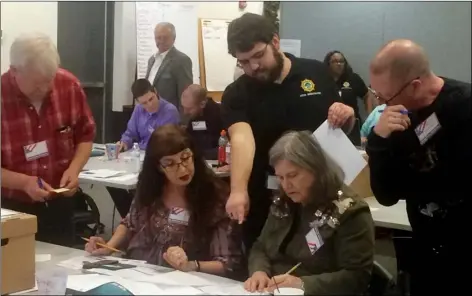  ?? AP PHOTO ?? Election officials in Newport News, Va., examine ballots that a computer failed to scan during a recount for a House of Delegates race Tuesday. Republican incumbent Del. David Yancey had won against Democratic challenger Shelly Simonds by just 10 votes...