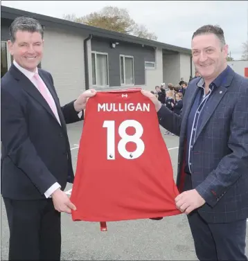  ??  ?? Principal, Pat Mulligan makes a special presentati­on of a Liverpool jersey to Patrick Mulligan at the official opening the second extension at St. Peter’s National School, Dromiskin.