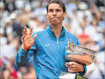  ??  ?? Spain’s Nadal poses with the Mousquetai­res Cup after his victory against Austria’s Dominic Thiem in the French Open final.