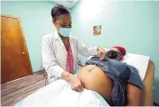  ?? ROGELIO V. SOLIS/AP ?? Dr. Felecia Brown, a midwife at Sisters in Birth, in Jackson, Miss.,left, measures the stomach of Kamiko Farris of Yazoo City, Miss.