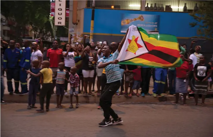  ??  ?? ZIMBABWEAN­S CELEBRATE the resignatio­n of Robert Mugabe.