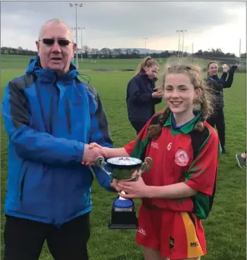  ??  ?? Jim Murphy presents the first year ‘A’ trophy to St Kevin’s captain Katy Halpin.