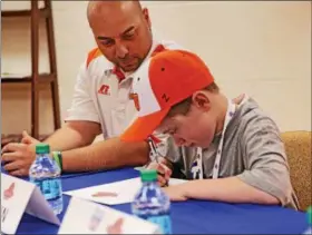  ?? CHRIS BARBER — DIGITAL FIRST MEDIA ?? Austin Willis signs his draft contract as coach Anthony Pla looks on.