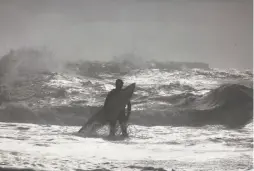  ??  ?? A wave looms behind Danny Cole of Santa Barbara, who is surfing Wednesday at Mavericks Beach in Half Moon Bay.