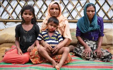  ??  ?? Opposite page: 11-year-old Jannatul moved to a new shelter after her family’s house was destroyed by a landslide. Top: Khadija (middle) sits with her young daughter, son and mother outside their new shelter. Middle: sand bag reinforced steps in Kutupalong settlement. Bottom: Rohingya refugees prepare for the monsoon by building new shelters.