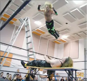  ?? Herald photo by J.W. Schnarr ?? Travis "The Heat" Copeland finishes Cyanide with a splash off a 14-foot ladder during the Tables, Ladders and Chairs main event at Pure Power Wrestling's TLC show in September. @JWSchnarrH­erald