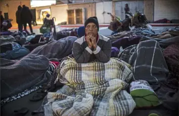  ?? Pedro Pardo/AFP/Getty Images ?? A group of Central American migrants — mostly from Honduras — moving toward the United States rests Friday near the Chaparral port of entry at the U.S.-Mexico border in Tijuana, Baja California state, Mexico.