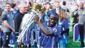  ??  ?? LONDON: Chelsea’s French midfielder N’Golo Kante poses with the English Premier League trophy, as players celebrate their league title win at the end of the Premier League football match between Chelsea and Sunderland at Stamford Bridge. — AFP