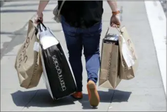  ?? MARCIO JOSE SANCHEZ — THE ASSOCIATED PRESS ?? In this photo, a shopper carries bags in San Francisco. On Monday, July 16, the Commerce Department releases U.S. retail sales data for June.