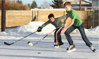  ?? JEFF STOKOE/THE CANADIAN PRESS ?? Elijah Chauvet, left, and Jaxon Thompson play hockey in Red Deer, Alta., on Wednesday.