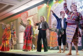  ??  ?? DOT Russia market rep Marina Nikuluva gamely dances with the Madayaw Dance Ensemble