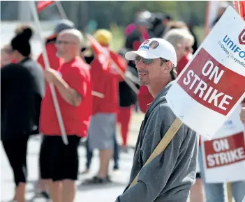  ?? BURCE CHESSELL/WOODSTOCK SENTINEL-REVIEW FILES ?? Striking workers walk the line outside the CAMI factory in Ingersoll, Ont., on Sept. 28. General Motors says it is considerin­g moving production of the Chevrolet Equinox from the plant as the strike go on.