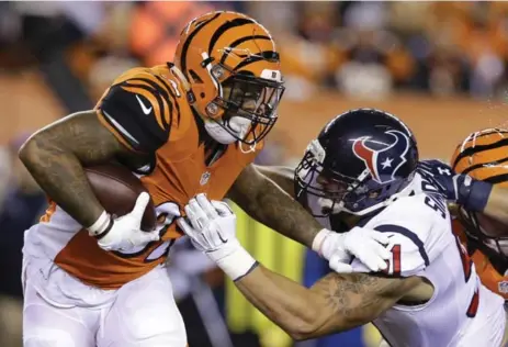  ?? MICHAEL CONROY/THE ASSOCIATED PRESS ?? Cincinnati Bengals running back Jeremy Hill runs against Houston Texans outside linebacker John Simon. Visit thestar.com/sports for game coverage.