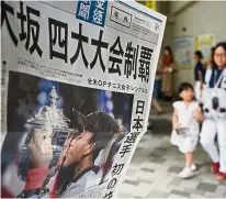  ?? — AFP ?? Latest, latest: This picture shows an extra edition of a Japanese newspaper reporting tennis player Naomi Osaka’s victory at the US Open in Tokyo yesterday. Her victory over legendary Serena Williams gave the nation some rare good news after a summer of deadly natural disasters.