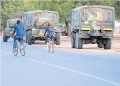  ??  ?? CRISIS AVERTED: Pupils on bikes drive next to a military convoi leaving the border with Gambia, near the village of Toubacouta, Senegal, yesterday.