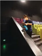  ?? FU DING / FOR CHINA DAILY ?? A worker at a cinema in Beijing disinfects aisles and seats.