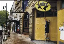  ?? JAY JANNER — AUSTIN AMERICAN-STATESMAN VIA AP ?? Matthew Gaskamp, General Manager of The Lodge, boards up his bar on East Sixth Street in Austin, Texas, on Friday.