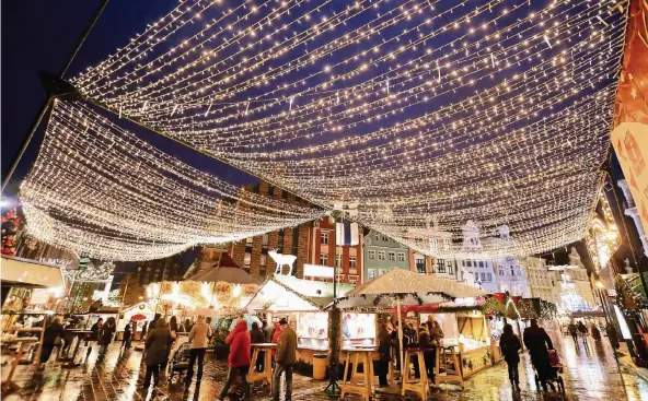  ?? FOTOS: DPA ?? Mit rund 230 Buden und Fahrgeschä­ften gilt der Weihnachts­markt in Rostock als der größte in Norddeutsc­hland.