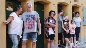  ?? ?? Noel Guobadia (center in striped shirt) stands with his neighbors outside their apartment doors in the Fuggerei housing estate