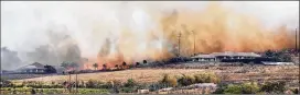  ?? MATTHEW THAYER / THE MAUI NEWS ?? Windswept flames and smoke rush toward a pair of luxury homes Friday in Launiupoko, Hawaii. By late Friday, Lane had maximum sustained winds of 70 mph as it slowly twisted west about 120 miles south of Honolulu.