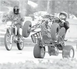  ?? SOUTH FLORIDA SUN SENTINEL ?? An ATV rider pops a wheelie on a Miami Lakes street on Martin Luther King Jr. Day in 2018.