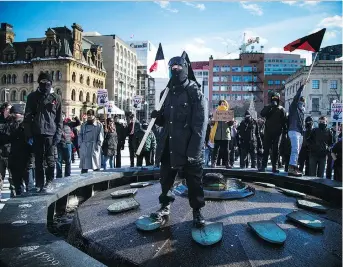  ?? PHOTOS: ASHLEY FRASER ?? Anti-Muslim and anti-racist protesters voiced their opposing views Sunday on Parliament Hill. One masked anti racist protester stood in the Centennial Flame during the demonstrat­ions.