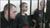  ?? AP PHOTO ?? Two British citizens Aiden Aslin, left, and Shaun Pinner, right, and Moroccan Saaudun Brahim, center, sit behind bars in a courtroom in Donetsk, in the territory which is under the Government of the Donetsk People’s Republic control, eastern Ukraine, Thursday.