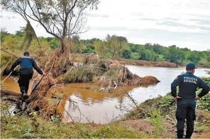  ??  ?? Policías estatales buscan a personas desapareci­das en las riberas de los ríos Humaya y Culiacán.