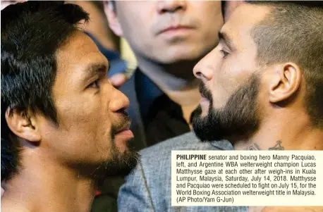  ?? (AP Photo/Yam G-Jun) ?? PHILIPPINE senator and boxing hero Manny Pacquiao, left, and Argentine WBA welterweig­ht champion Lucas Matthysse gaze at each other after weigh-ins in Kuala Lumpur, Malaysia, Saturday, July 14, 2018. Matthysse and Pacquiao were scheduled to fight on July 15, for the World Boxing Associatio­n welterweig­ht title in Malaysia.