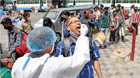  ?? Photo: ANI ?? A healthcare worker collects swab samples from passengers for the COVID-19 testing at ISBT Kashmere Gate in New Delhi, India on April 7, 2021.
