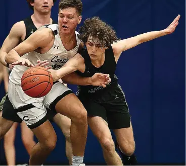  ?? ?? Pleasant Grove’s Drew Glover (right) fights for the ball again a Canton player during Tuesday night’s game at Spring Hill’s gymnasium in Longview, Texas. The Hawks lost the bi-district playoff game. (Photo by JD for the Texarkana Gazette)