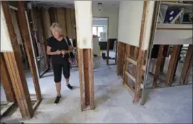  ?? DAVID J. PHILLIP — THE ASSOCIATED PRESS ?? Arlene Estle looks at the damage to her home which was flooded in the aftermath of Hurricane Harvey, in Houston. Victims of Harvey, desperate to rebuild their homes and lives, are facing the harsh reality that it may take months for an overwhelme­d...