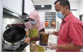  ?? — Bernama ?? Power couple: Muhammad Syafik and Nor Hafsah making ‘CheGuu Cincau’ in their home in Kuantan.