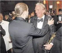  ??  ?? DONALD SUTHERLAND, right, is congratula­ted for his honorary Oscar, one of four individual­s to receive the award this year.